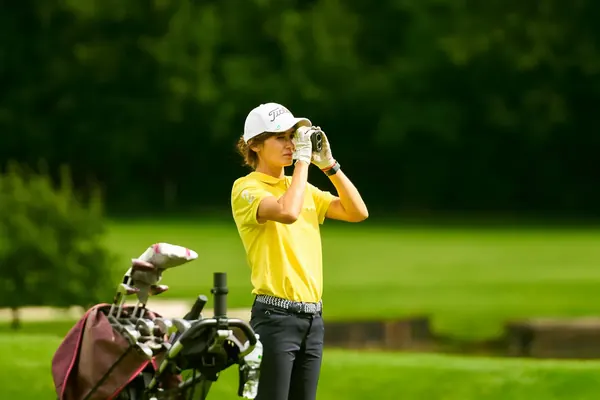 Катя в жёлтой футболке на поле с дальномером
